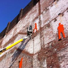 Silhouettes added to brick wall of vacant building