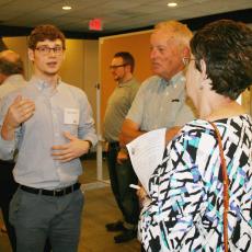 Dungan Becker explains his work during Summer Scholar poster session to Massachusetts Grange members, Scott Davis and Kathy Peterson, Chair, Executive Committee