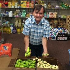 Frank Mangan of the Stockbridge School of Agriculture at Monrovia African Market in Worcester holding garden egg (white) and jiló (green) grown at the UMass Research Farm in Deerfield MA