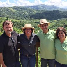 On a visit to Puerto Rico to talk about collaborations to provide culturally-appropriate fresh produce to Latino markets in Massachusetts, Frank Mangan (left) is shown with Puerto Rican Secretary of Agriculture Dr. Myrna Comas-Pagán, and the owners of the coffee farm in the background.