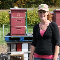 Kristen Hanley, Orchard Administrator checks bee hives