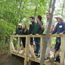 UMass students,Tara McElhinney and Jack Mulcahy, review invasive speciees with residents at Abbey Brook, Springfield