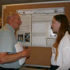 Scott Davis, Mass Grange, picks up some honey bee tips from student Bryanna Joyce at poster session