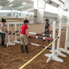 Students setting up horse jump at Hadley Farm horse barn