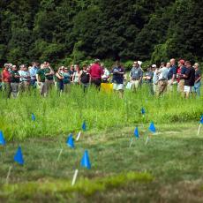 Photo of weed identification plots at the Joseph Troll Turf Research Center in the foreground, while Extension Weed Specialist Randy Prostak presents in the background 