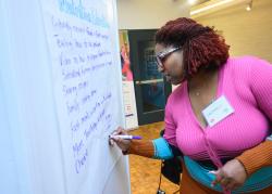 Lacresha Bowers writes on a board an outline of a plan for the Nutrition Education Program