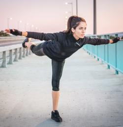 young woman standing on one foot