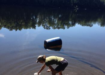 Research technician and Stockbridge undergraduate, Genevieve Higgins collecting water samples from the Connecticut River in Deerfield.