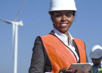 woman standing in front of wind turbine