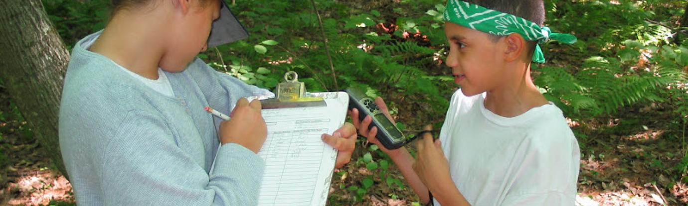 two kids collecting forestry data