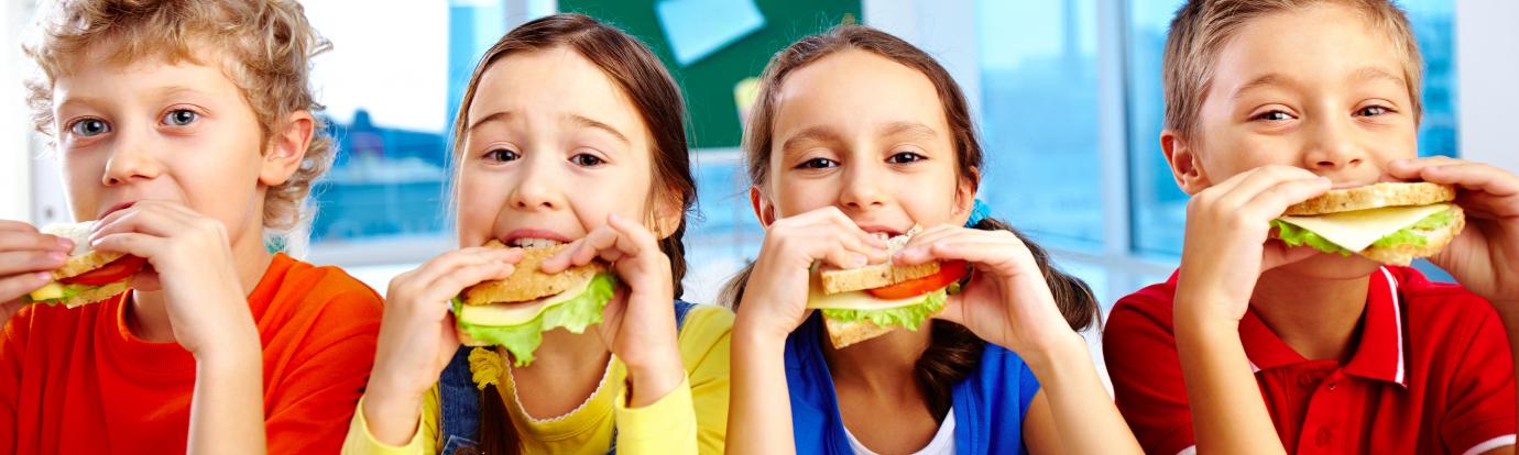 four children eating sandwiches