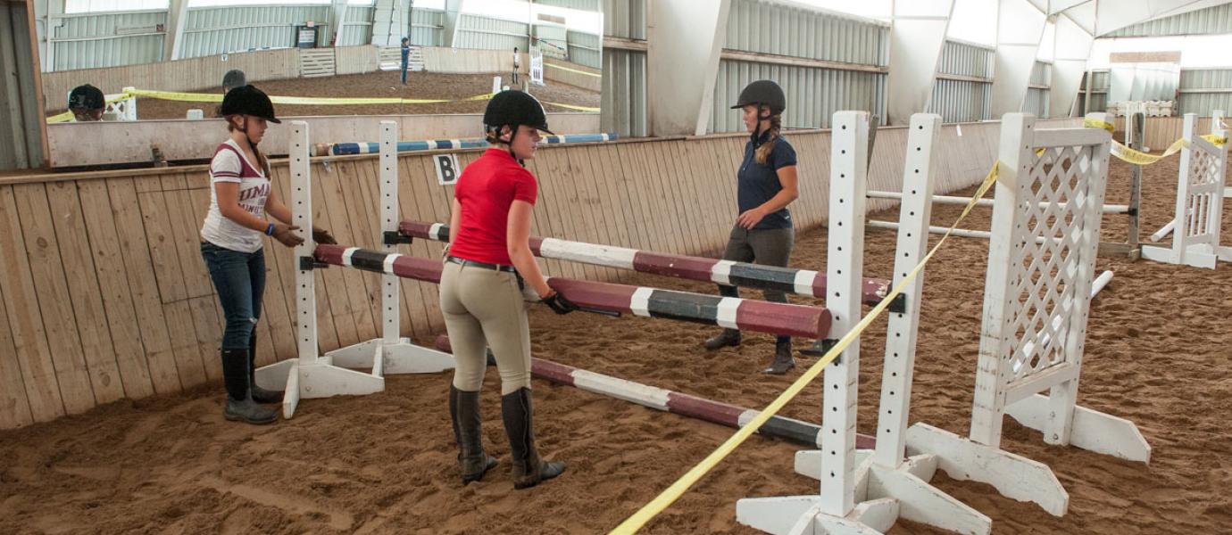 Students setting up horse jump at Hadley Farm horse barn